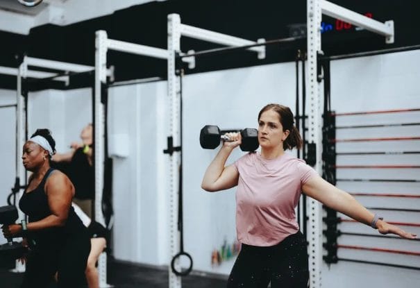 Woman balancing while holding dumbbell during functional training at CrossFit Plainfield