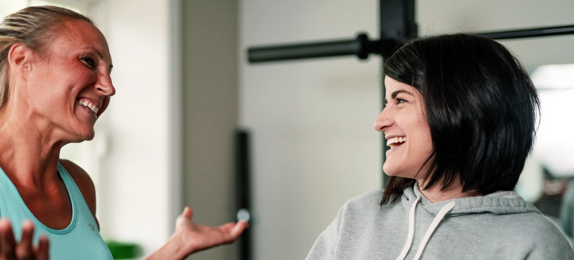 Two women smiling and talking during workout session at CrossFit Plainfield